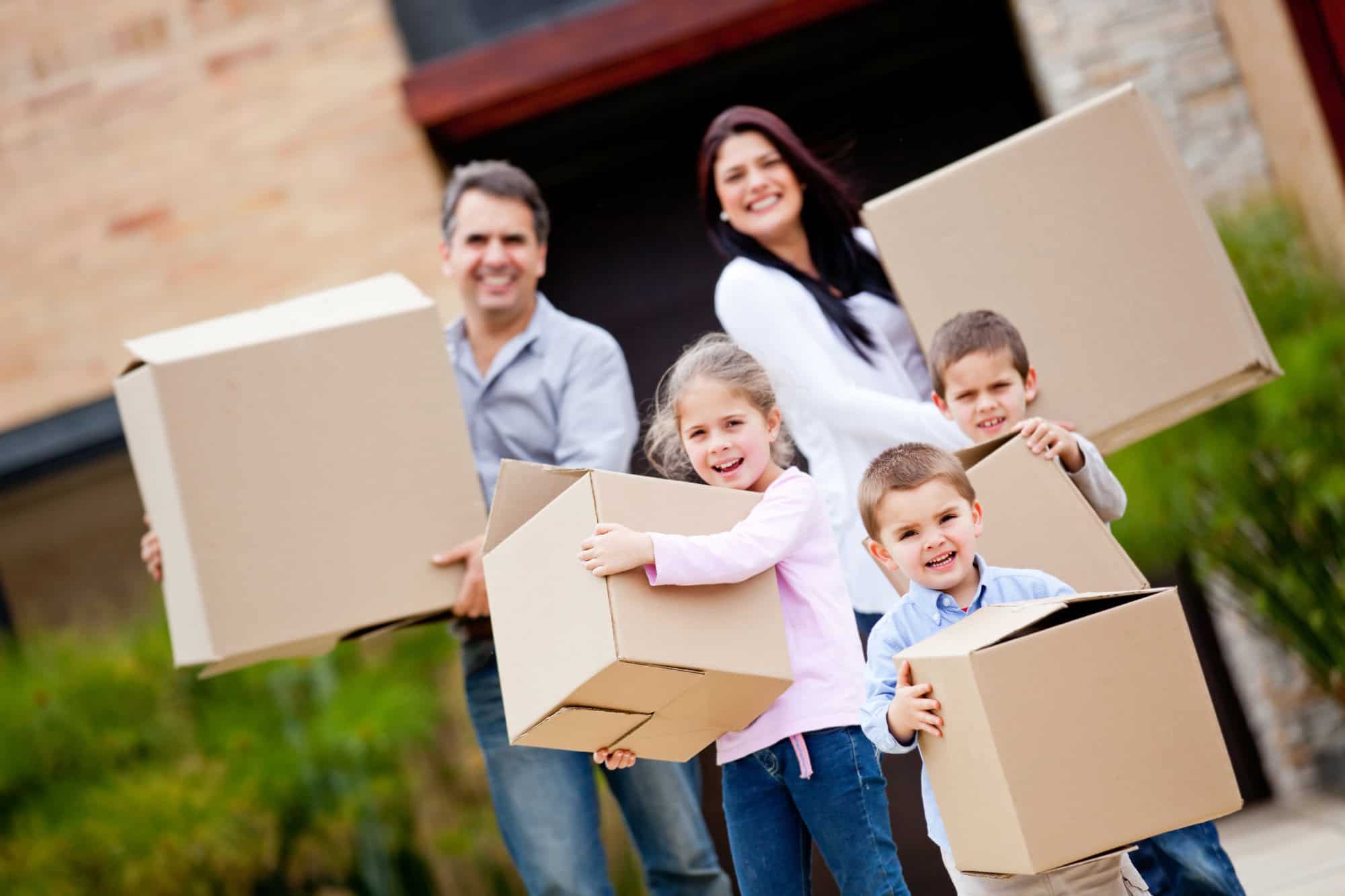 Happy family moving house and carrying boxes